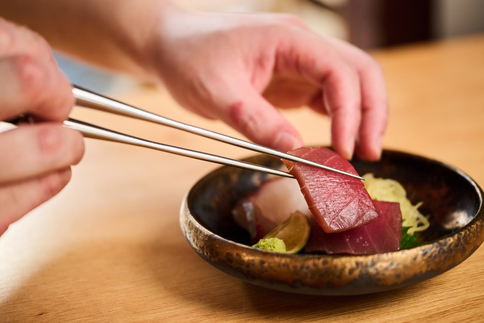 和食料理「廻」の料理人が、お造りを器に盛り付ける様子