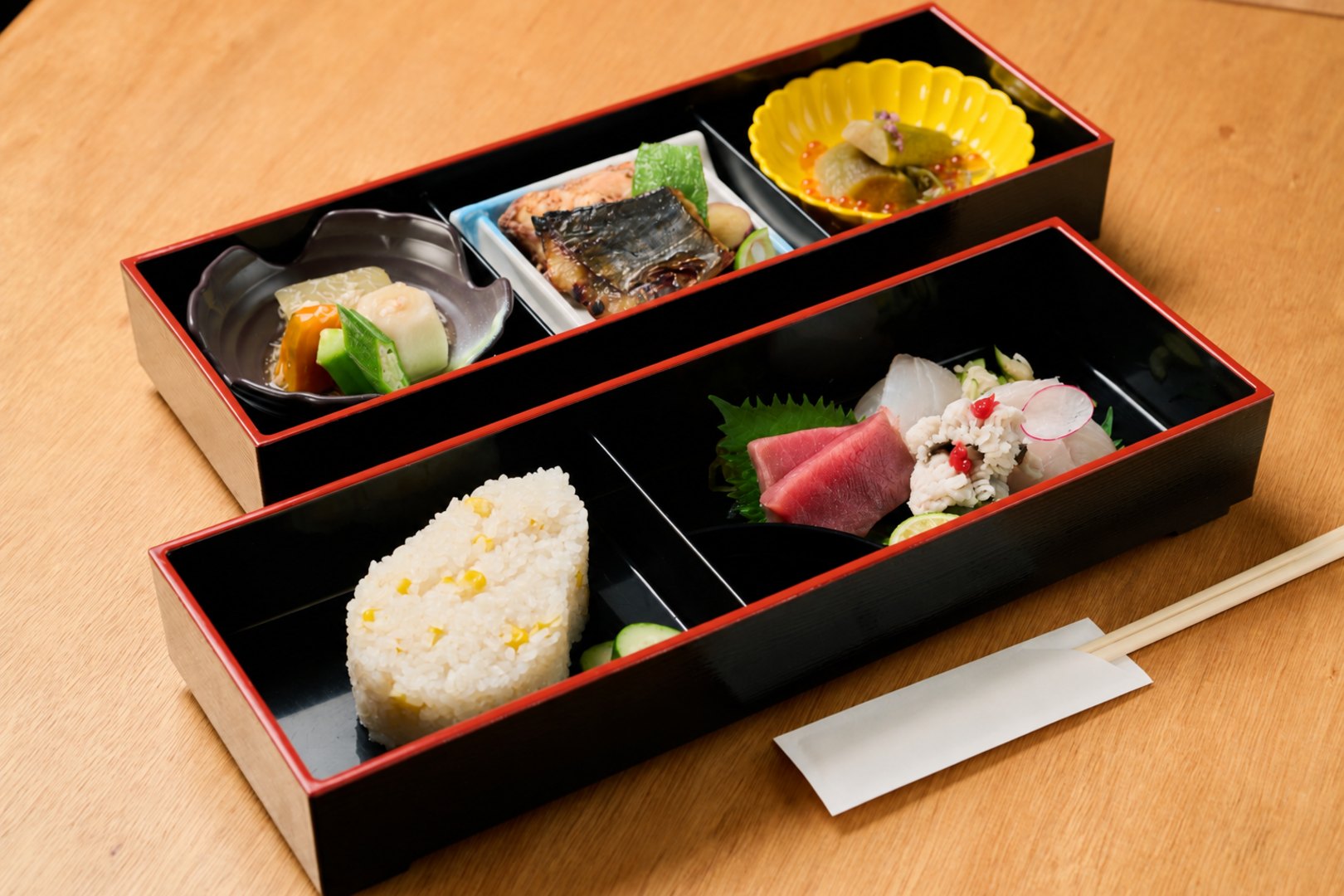 和食料理「廻」の特製お重（大人用二段）。お造り・焼き魚・煮物・季節の小鉢・季節のご飯